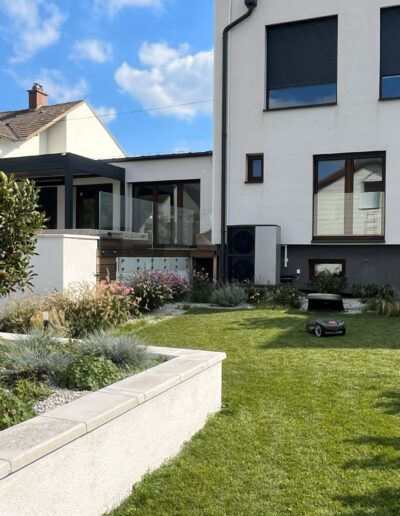 Realizácia okrasnej záhrady s okrasnými vyvýšenými záhonmi a automatickou kosačkou v Hainburg – realizácia Creanatura